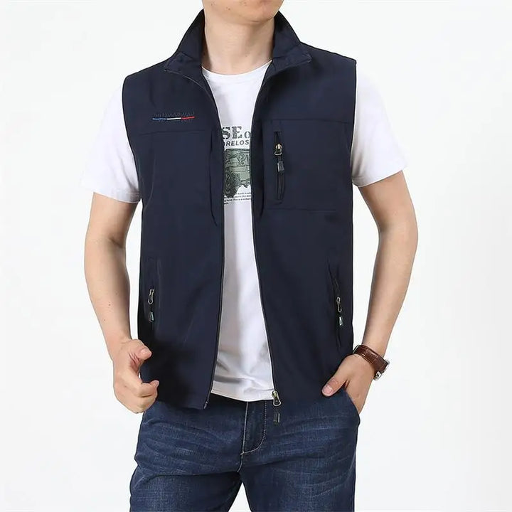 Mann trägt dunkelblaue Weste über weißem T-Shirt, lässiger Stil, Mode für Herren, Freizeitkleidung, Outdoor-Weste, Reißverschlusstaschen.
