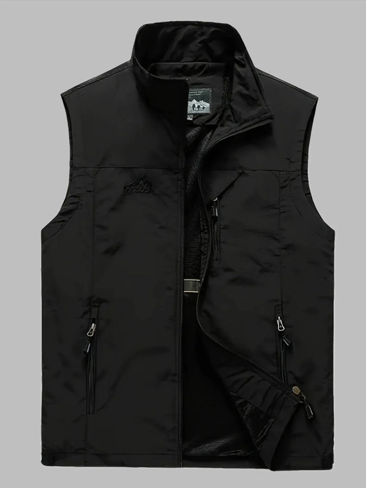 Schwarze Herrenweste mit Stehkragen, Reißverschluss und Taschen, ideal für Outdoor-Aktivitäten. Funktionale, modische Weste für Herbst und Winter.