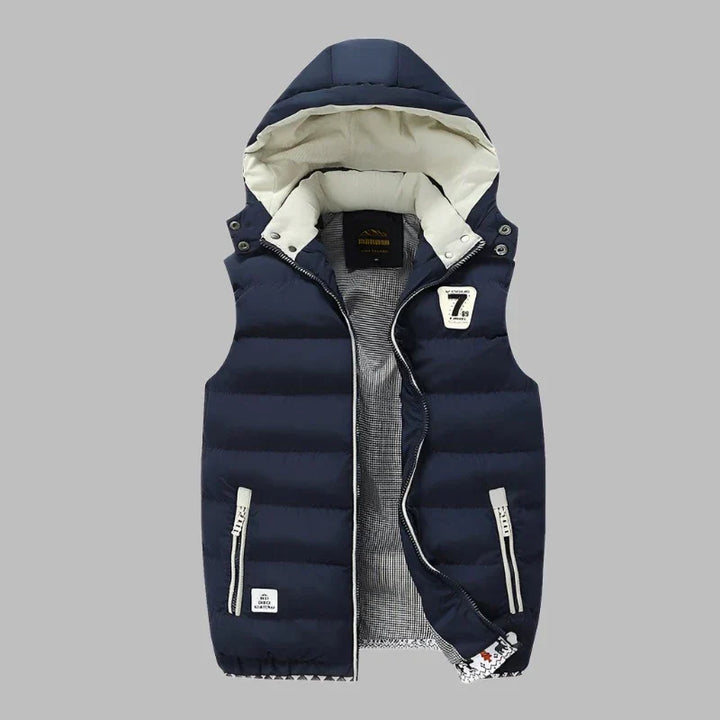 Dunkelblaue Herren-Steppweste mit Kapuze, Reißverschlusstaschen und gestepptem Design. Modische Winterbekleidung, ideal für Outdoor-Aktivitäten.