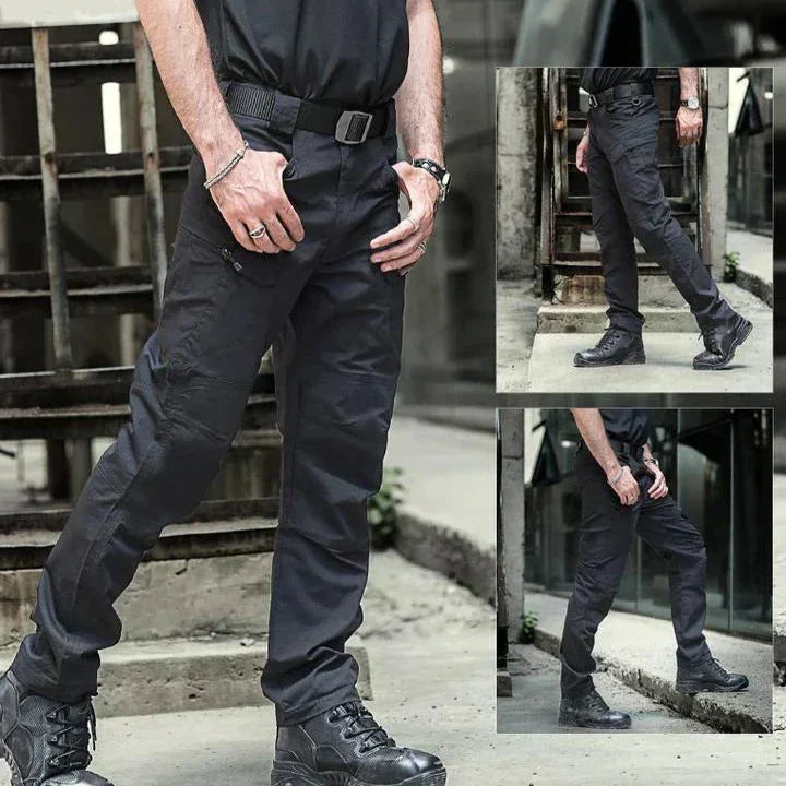 Mann trägt schwarze taktische Hose und Stiefel, urbaner Hintergrund. Robuste Outdoor-Bekleidung, ideal für Abenteuer und Arbeitseinsätze.