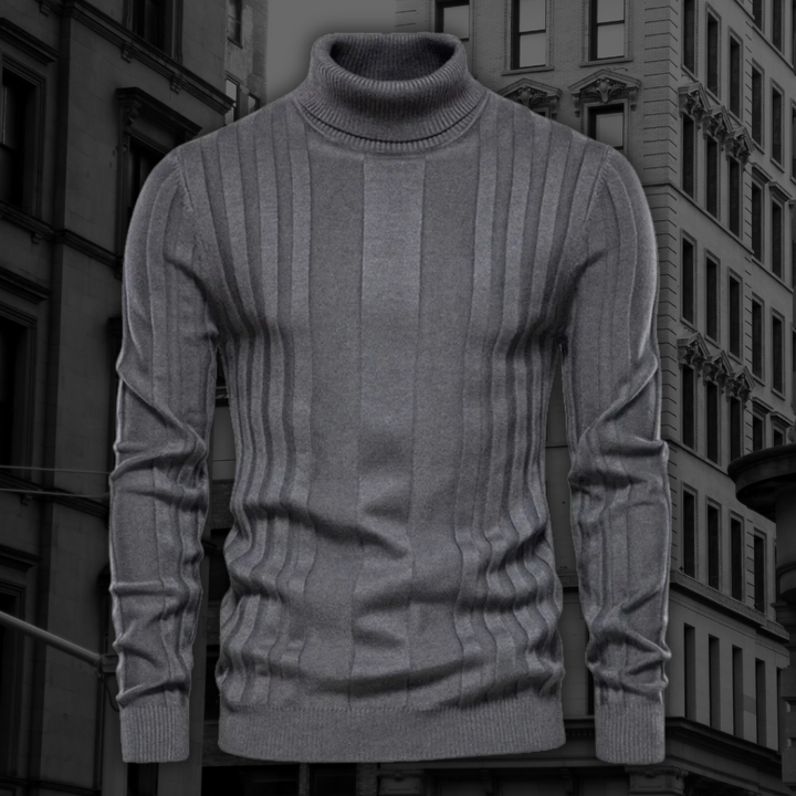 Grauer Rollkragenpullover aus Wolle mit Rippstrickmuster vor urbanem Hintergrund. Elegante Herrenmode, stilvoll und warm für Herbst und Winter.