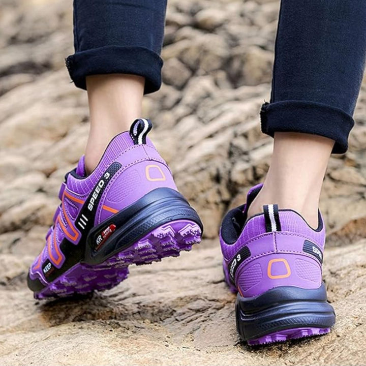 Lila Wanderschuhe auf felsigem Untergrund, robuste Sohle, Outdoor-Schuhe für Damen, ideal für Trekking und Bergwandern, bequeme Passform.
