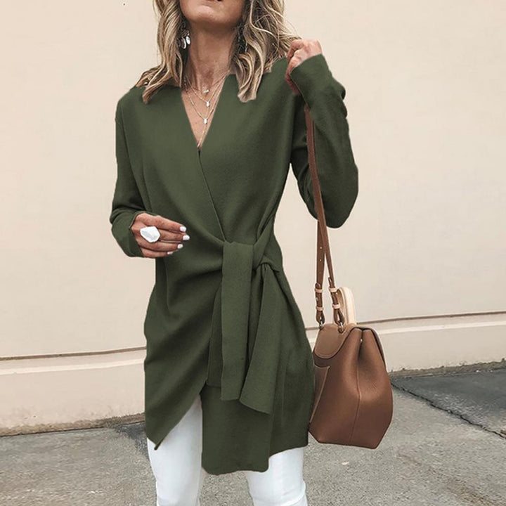 Frau in olivgrünem Wickelkleid mit brauner Handtasche und weißer Hose, modisch gekleidet, Herbstmode, Streetstyle, elegantes Outfit.