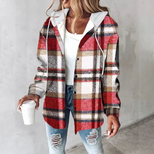 Frau in kariertem Flanellhemd mit Kapuze, weißem Top und zerrissenen Jeans hält Kaffeebecher. Modetrend, lässiger Herbstlook, Streetstyle.