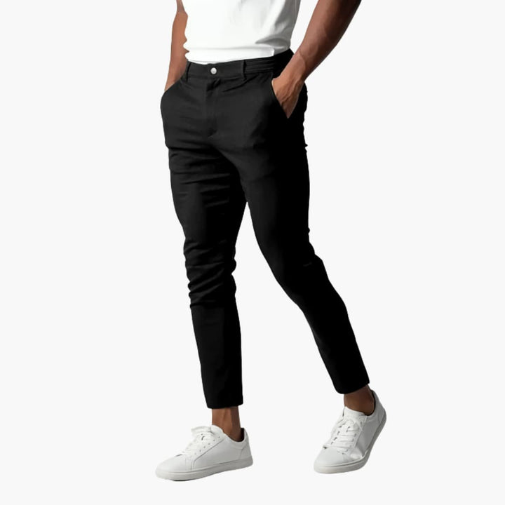 Schwarze Chinohose für Herren, kombiniert mit weißen Sneakers und weißem T-Shirt. Modische Herrenbekleidung, ideal für Freizeit und Büro.