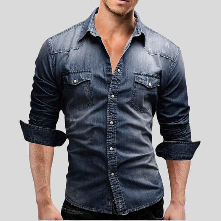 Mann in dunkelblauem Jeanshemd mit aufgerollten Ärmeln, Brusttaschen und Knopfleiste. Modetrend, Herrenbekleidung, lässiger Stil.