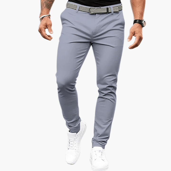 Herrenmode: Graue Chinohose, schmal geschnitten, kombiniert mit weißem Sneaker und Gürtel. Stilvolle Freizeitkleidung für Männer.