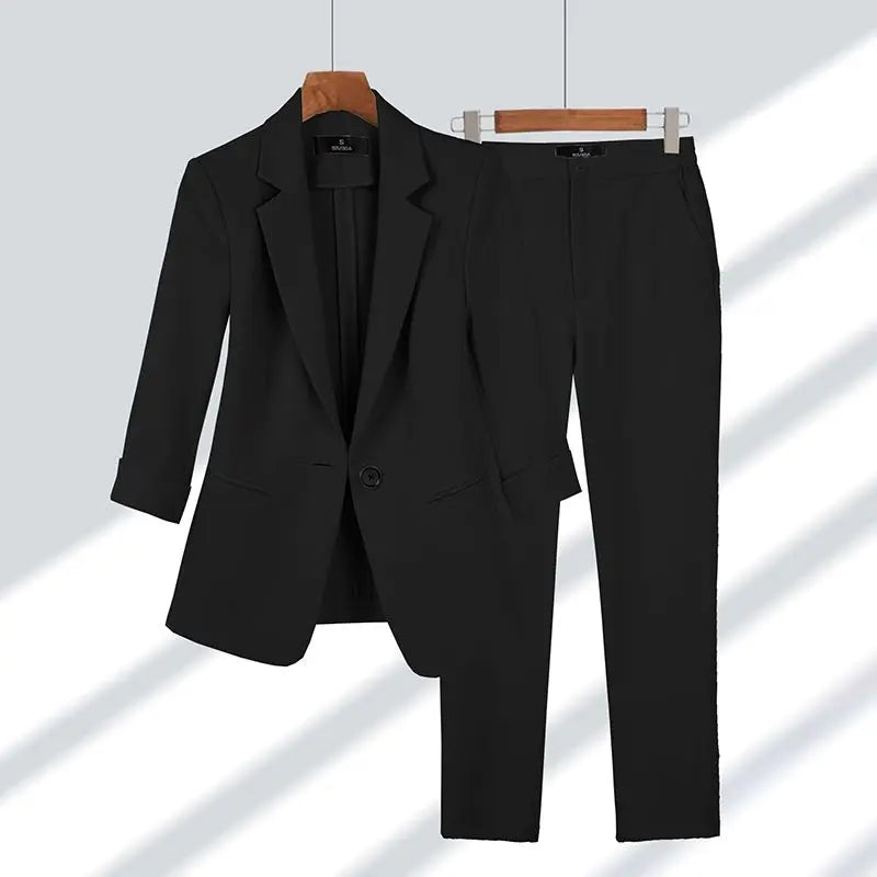 Schwarzer Damenanzug mit Blazer und Hose auf Kleiderbügeln, elegantes Business-Outfit, klassische Mode, formelle Damenbekleidung.