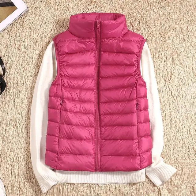Rosa Daunenweste auf cremefarbenem Pullover, modische Winterbekleidung, warme Damenweste, gesteppte Jacke, stilvoll und bequem.