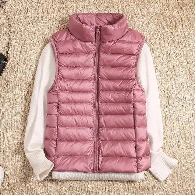 Rosa Steppweste auf cremefarbenem Pullover, modische Damenbekleidung, Herbstmode, warme ärmellose Jacke, stilvoll und bequem.