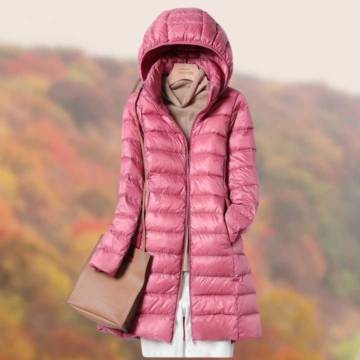 Rosa Daunenjacke mit Kapuze, kombiniert mit beiger Handtasche und Pullover, vor herbstlichem Hintergrund. Perfekt für Herbstmode und Outdoor-Aktivitäten.