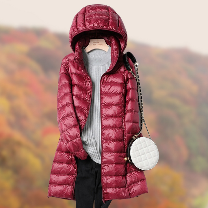 Rote Daunenjacke mit Kapuze, grauem Pullover und schwarzer Hose vor herbstlichem Hintergrund. Modische Damenbekleidung, Herbstmode, Outdoor-Outfit.