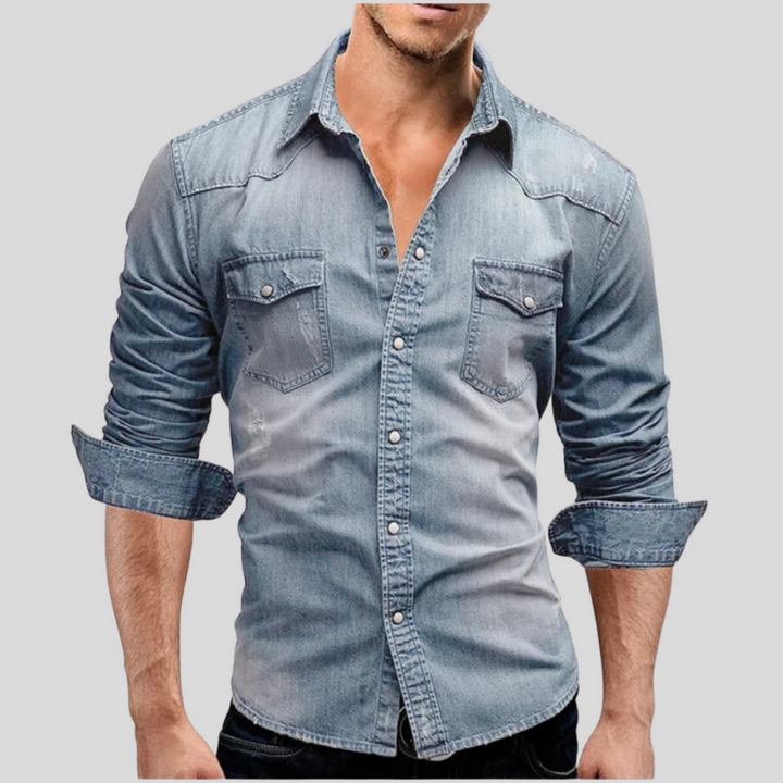 Mann in hellblauem Jeanshemd mit aufgerollten Ärmeln, zwei Brusttaschen und Knopfleiste. Modetrend, Freizeitkleidung, Herrenmode.