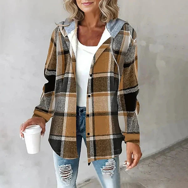 Frau in kariertem Hemd, Jeans und weißem Top hält Kaffeebecher. Modetrend, lässiger Look, Herbstmode, Damenbekleidung, Streetstyle.