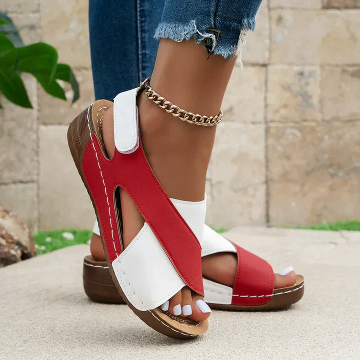 Damen Sandalen in Rot-Weiß, offenes Design, bequeme Keilabsätze, kombiniert mit blauer Jeans und goldener Fußkette, Sommermode.