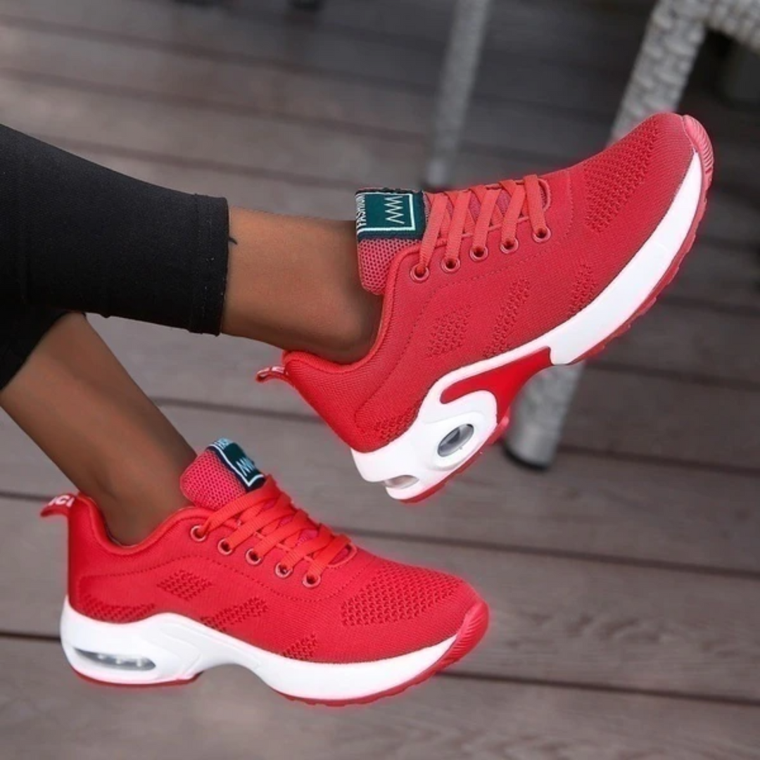 Rote Damen-Sneaker mit weißer Sohle, atmungsaktivem Mesh-Obermaterial und Luftpolsterung, ideal für Sport und Freizeit.