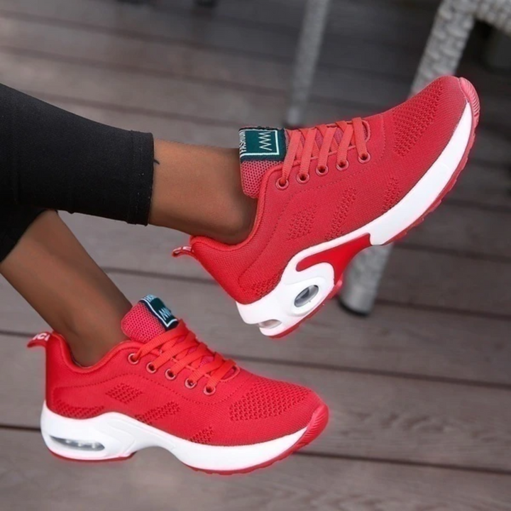 Rote Damen-Sneaker mit weißer Sohle, atmungsaktivem Mesh-Obermaterial und Luftpolsterung, ideal für Sport und Freizeit.