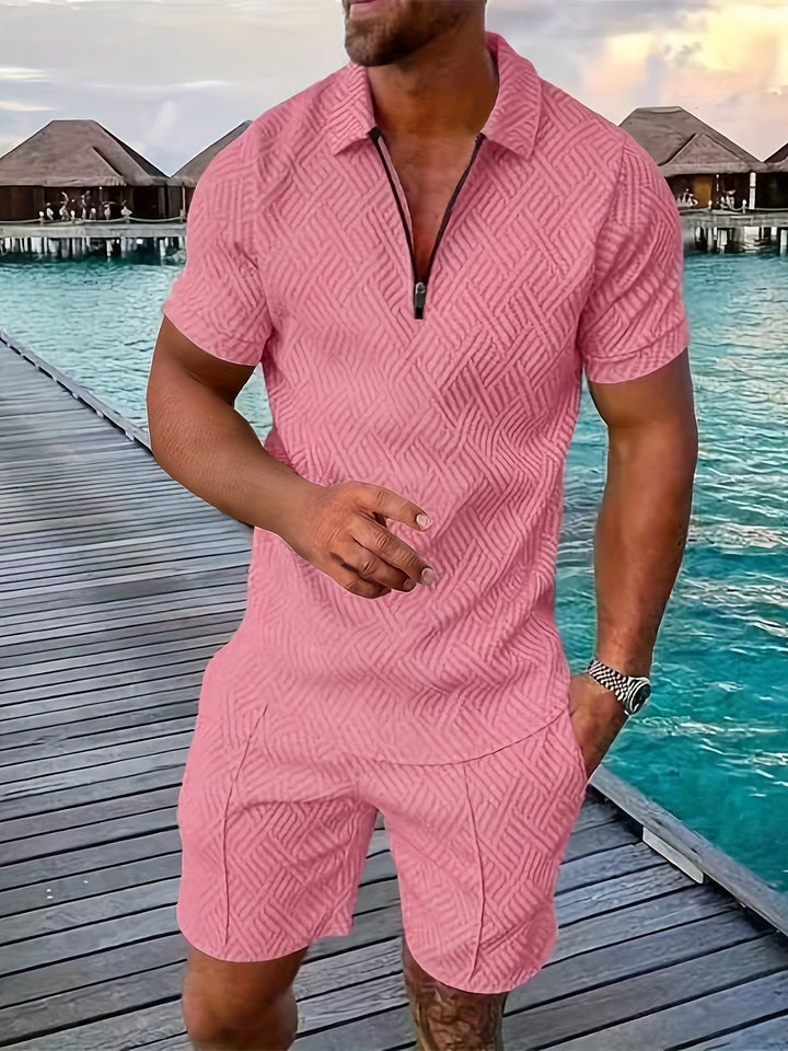 Mann in rosa Sommeranzug auf Holzsteg am Meer, tropische Bungalows im Hintergrund, stilvolle Freizeitmode, Urlaubskleidung, Herrenmode.