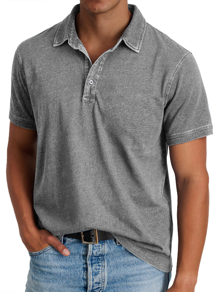 Graues Poloshirt aus Baumwolle, kurzärmelig, mit Kragen und Knopfleiste, getragen von einem Mann in blauen Jeans. Ideal für Freizeitmode.