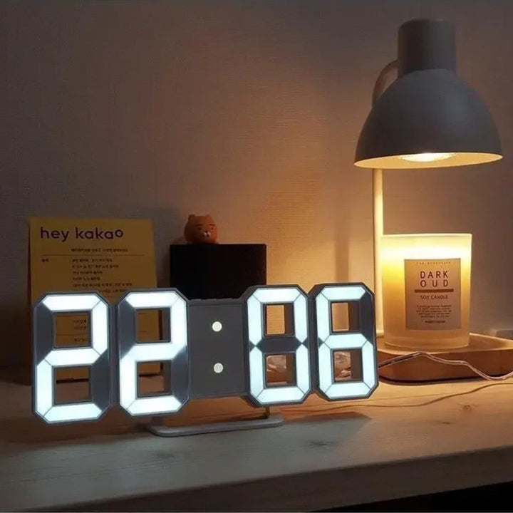 LED-Digitaluhr auf Tisch neben Lampe und Duftkerze, modernes minimalistisches Design, leuchtende Ziffern, stilvolle Wohnkultur, Zeit 20:06.