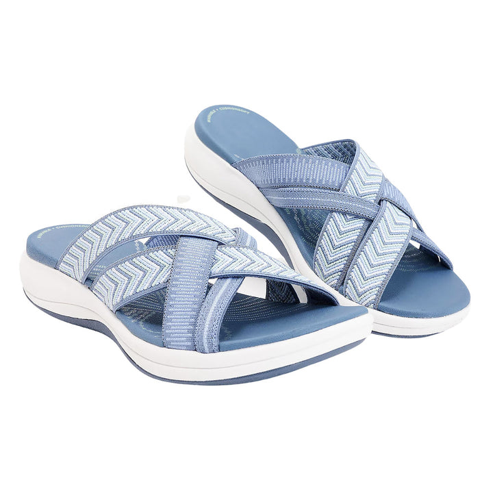 Blaue Damen-Sandalen mit überkreuzten Riemen und weißer Sohle, ideal für Sommermode und Freizeitkleidung. Bequeme, stilvolle Sommerschuhe.