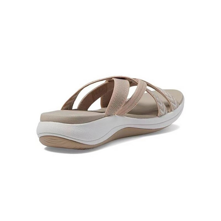 Beige Damen-Sandale mit weißen Sohlen, ergonomischem Design und überkreuzten Riemen. Bequemes Schuhwerk für Sommer und Freizeit.