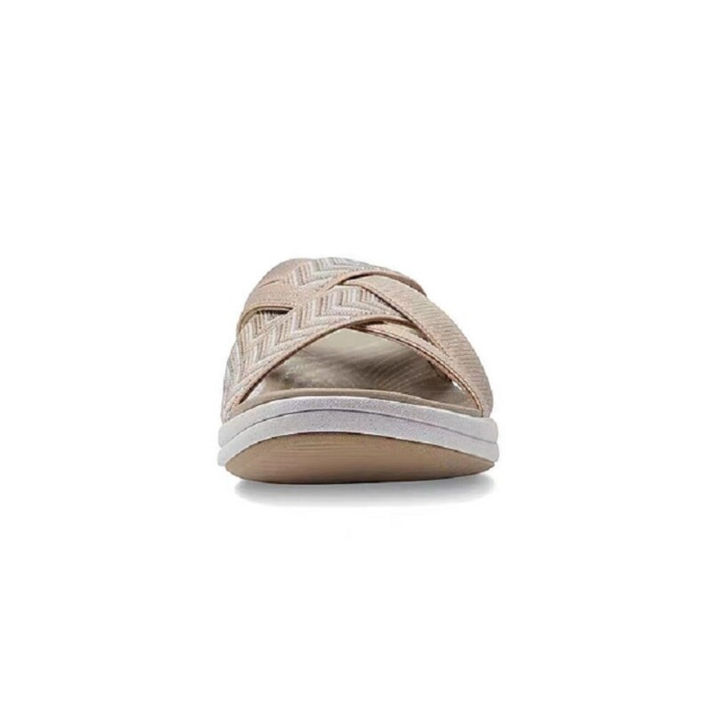 Beige Damen-Sandale mit überkreuzten Riemen und flacher Sohle, ideal für Sommermode und Freizeitkleidung. Komfortable und stilvolle Fußbekleidung.