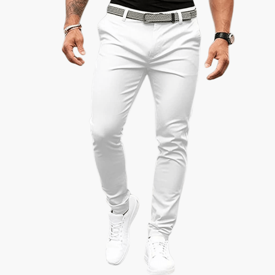 Herrenmode: Weiße Chinohose, schmal geschnitten, kombiniert mit weißem Gürtel und Sneakers. Eleganter Look für Freizeit und Büro.
