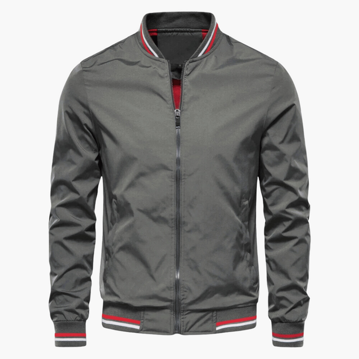 Graue Bomberjacke mit Reißverschluss, gestreiftem Kragen und Bündchen. Modische Herrenjacke, ideal für Herbst und Frühling.
