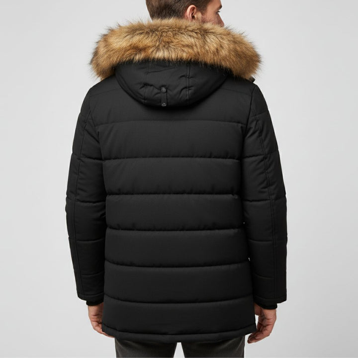 Rückansicht eines Mannes, der einen schwarzen Stepp-Parka mit einer Kapuze mit Kunstpelzbesatz trägt.
