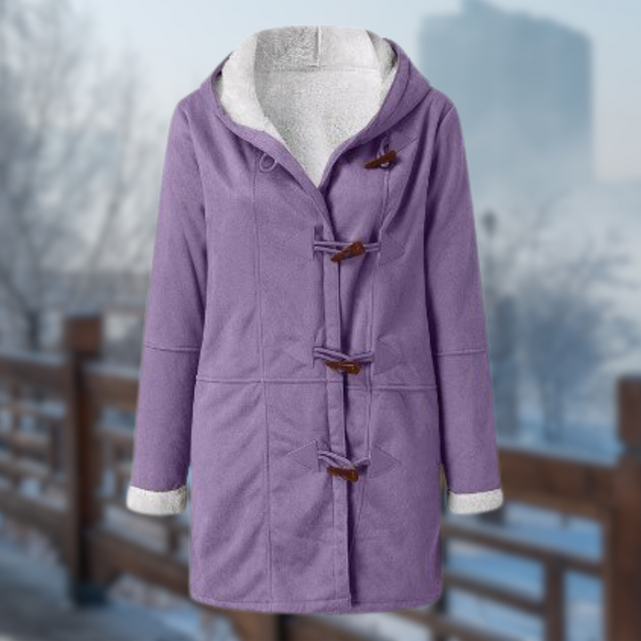 Lila Damen-Dufflecoat mit Knebelverschlüssen, Kapuze und Fleece-Futter, ideal für Wintermode. Hintergrund: Verschwommene Winterlandschaft.
