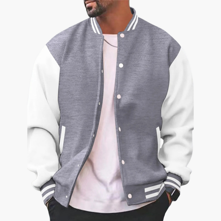 Graue Collegejacke mit weißen Ärmeln, getragen von einem Mann. Modische Herrenjacke, ideal für Freizeit und Sport. Trendige Streetwear.