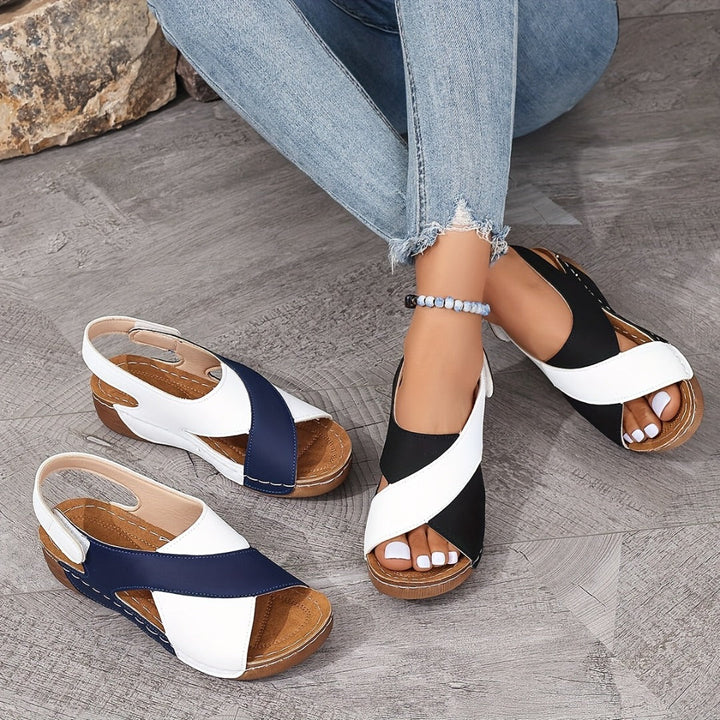 Damen-Sandalen mit Keilabsatz in Blau, Weiß und Schwarz, getragen mit Jeans. Bequeme Sommerschuhe, ideal für Freizeit und Alltag.