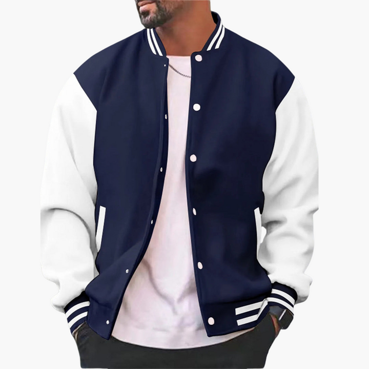 Mann in modischer Collegejacke, dunkelblau mit weißen Ärmeln, trägt weißes T-Shirt. Trendige Herrenmode, lässiger Stil, Streetwear-Look.