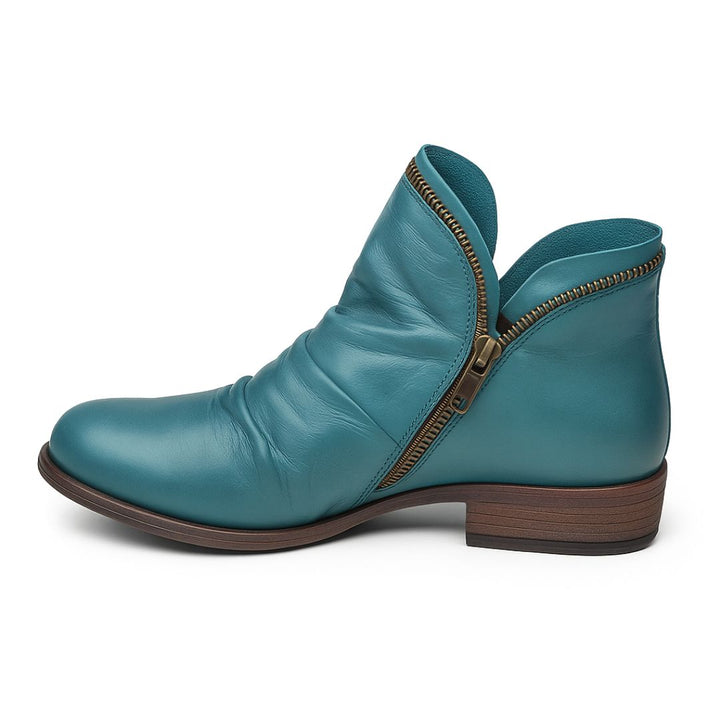 Türkiser Damenstiefel aus Leder mit seitlichem Reißverschluss und flachem Absatz. Modischer, bequemer Schuh für Herbst und Winter.