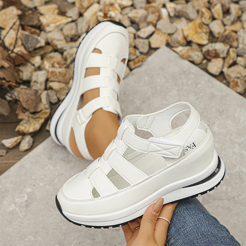 Weiße Sandalen mit Plateau, sportlich und modern, auf Kieselsteinen. Bequeme Damen-Sommerschuhe, ideal für Freizeit und Outdoor-Aktivitäten.