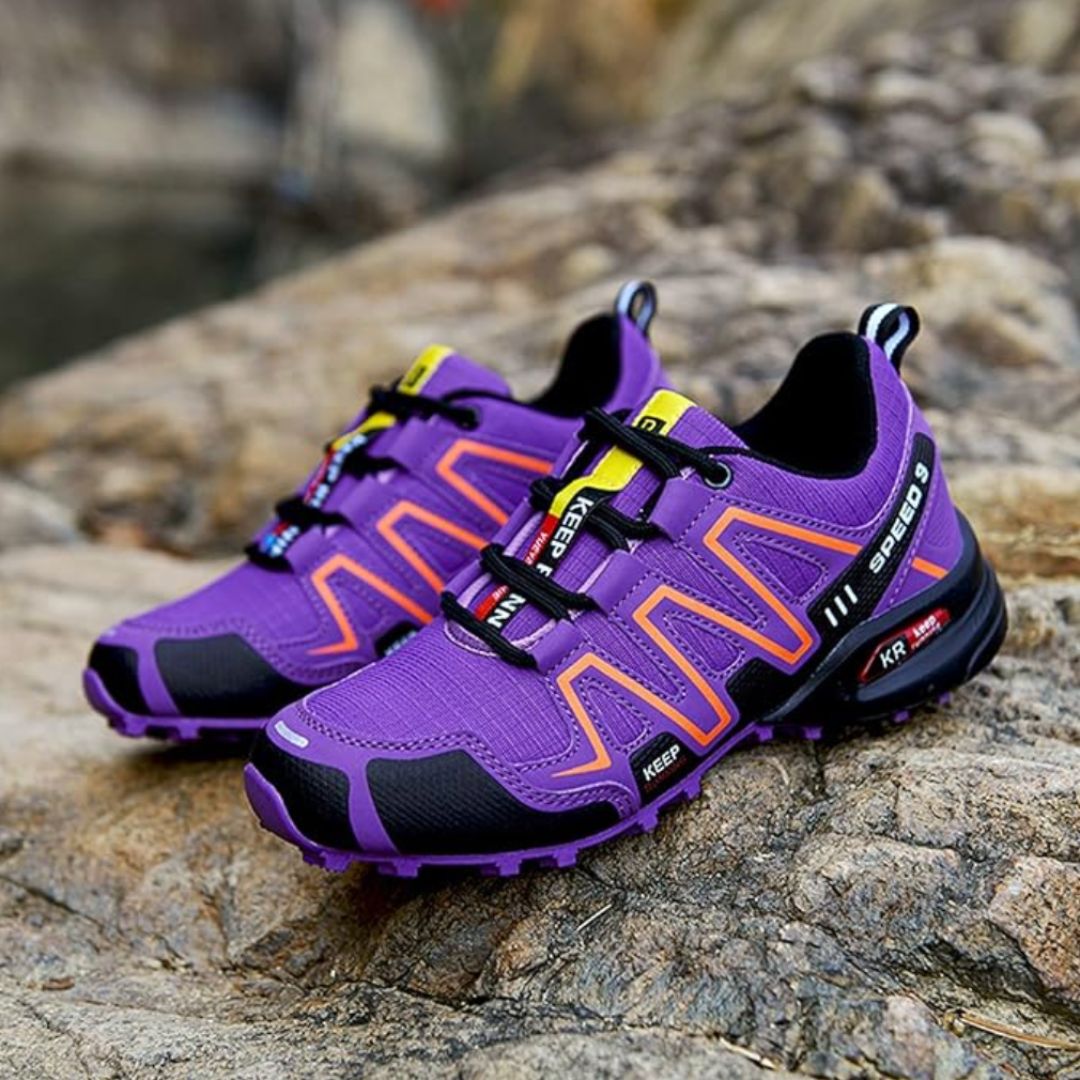 Lila Outdoor-Laufschuhe auf Felsen, sportliches Design, robuste Sohle, ideal für Trailrunning und Wandern, modische Sportschuhe für Damen und Herren.