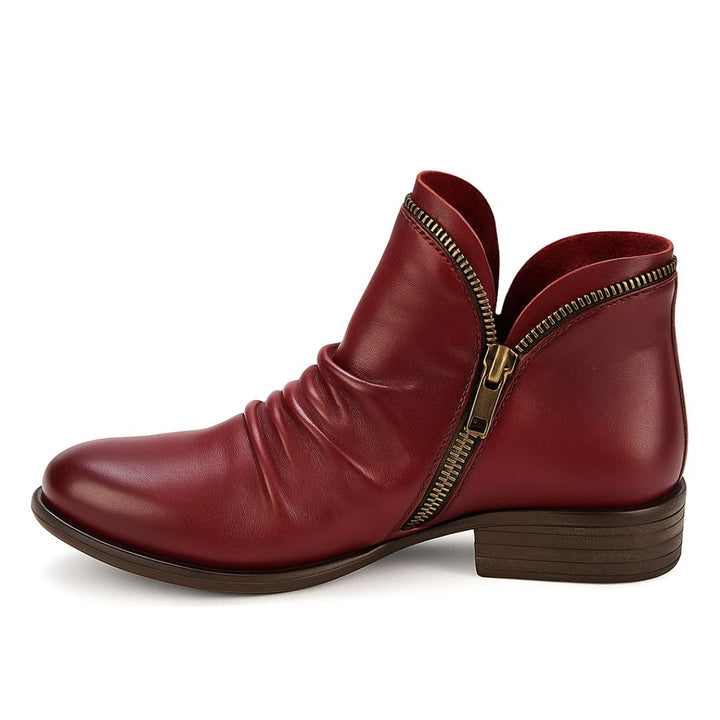 Roter Damenstiefel aus Leder mit seitlichem Reißverschluss, flachem Absatz und gerafftem Design. Modischer Herbstschuh, bequem und stilvoll.