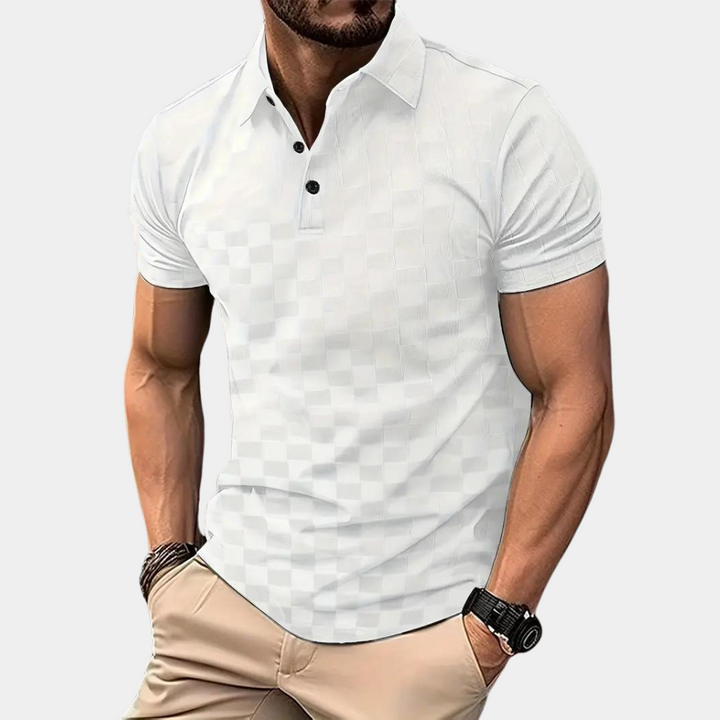 Mann trägt weißes Polohemd mit Karomuster, kurze Ärmel, schwarze Knöpfe. Modischer Freizeitlook, ideal für Sommer und Freizeitkleidung.
