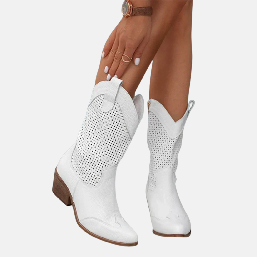 Weiße Cowboystiefel aus Leder mit perforiertem Muster, mittlerem Absatz und spitzer Zehenpartie. Damenmode, Westernstil, trendige Schuhe.