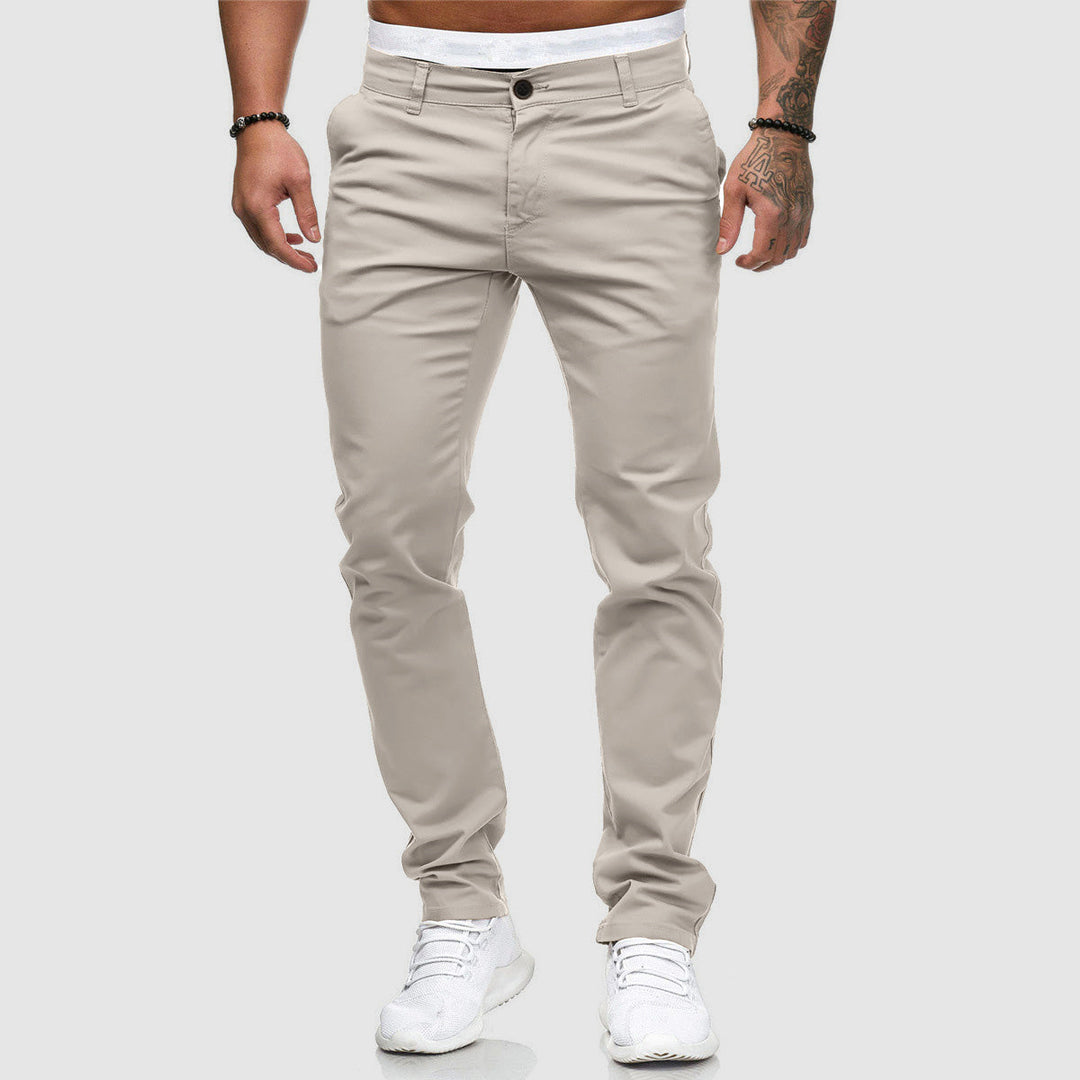 Beige Herren-Chinohose, modern geschnitten, kombiniert mit weißen Sneakers. Perfekt für lässige und stilvolle Outfits. Ideal für Freizeitmode.