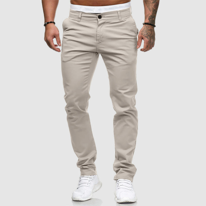 Beige Herren-Chinohose, modern geschnitten, kombiniert mit weißen Sneakers. Perfekt für lässige und stilvolle Outfits. Ideal für Freizeitmode.