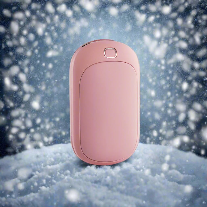 Rosa Handwärmer im Schnee, tragbares Heizgerät, ideal für Winter, Outdoor-Aktivitäten, wiederaufladbar, kompakt, ergonomisches Design.