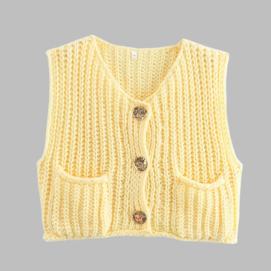 Gelbe Strickweste mit V-Ausschnitt, drei dekorativen Knöpfen und zwei Taschen, isoliert auf grauem Hintergrund. Modetrend, Damenbekleidung, Strickmode.