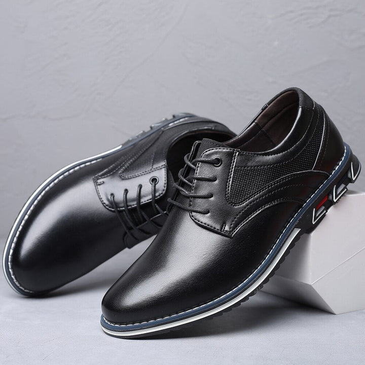 Schwarze Herren-Lederschnürschuhe mit blauer Sohle, elegantes Design, auf grauem Hintergrund. Perfekt für Business und formelle Anlässe.