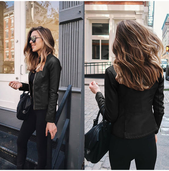 Frau in schwarzer Lederjacke und Sonnenbrille, hält schwarze Tasche, steht auf städtischer Straße. Modetrend, Streetstyle, Herbstmode.