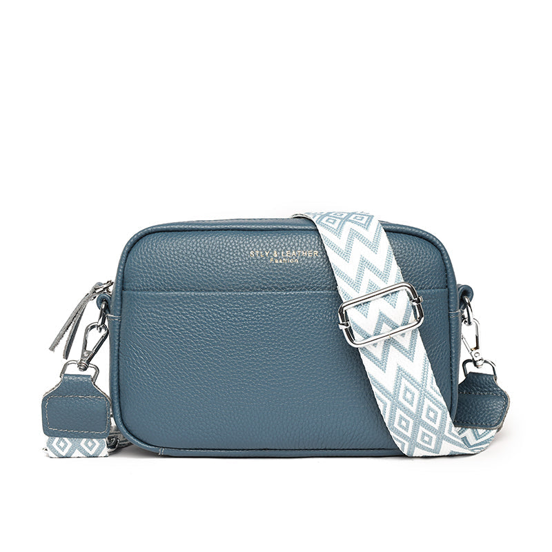 Blaue Lederhandtasche mit verstellbarem, gemustertem Schultergurt. Stilvolle Damen-Umhängetasche, ideal für Alltag und Freizeit.