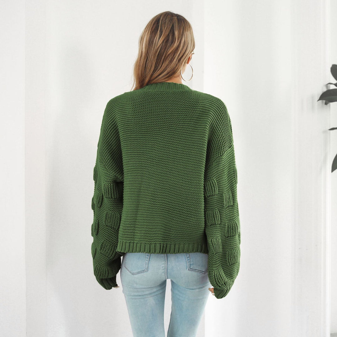 Frau in grünem Strickpullover mit Zopfmuster-Ärmeln, Rückansicht. Modetrend, Damenmode, Herbstoutfit, lässiger Stil, gemütlicher Look.