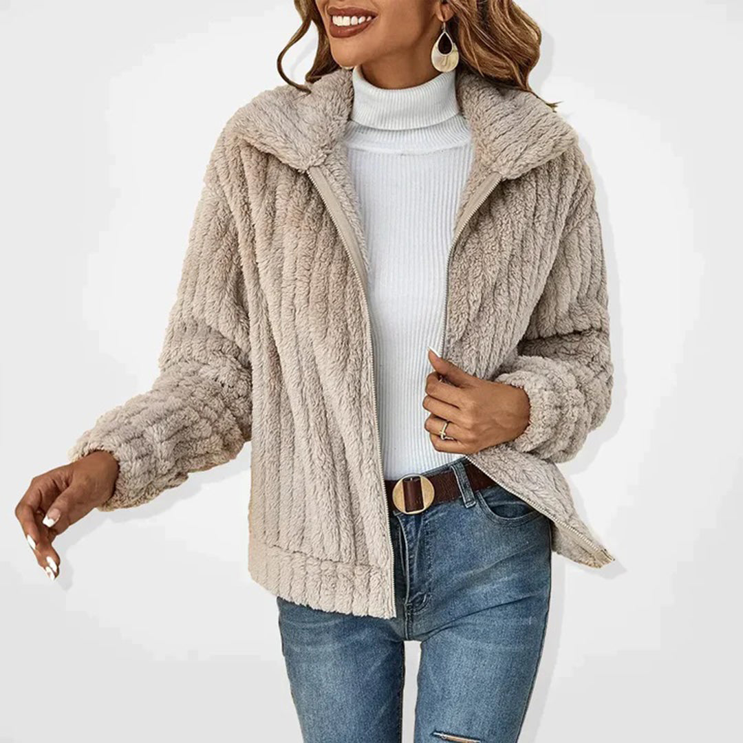 Frau in beiger Teddyfelljacke, weißem Rollkragenpullover und blauer Jeans. Modetrend, Wintermode, Damenbekleidung, stilvoll, warm.