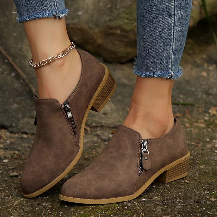 Damen braune Halbschuhe mit Reißverschluss, kombiniert mit blauen Jeans. Modische, bequeme Schuhe für Herbst, ideal für Freizeit und Alltag.